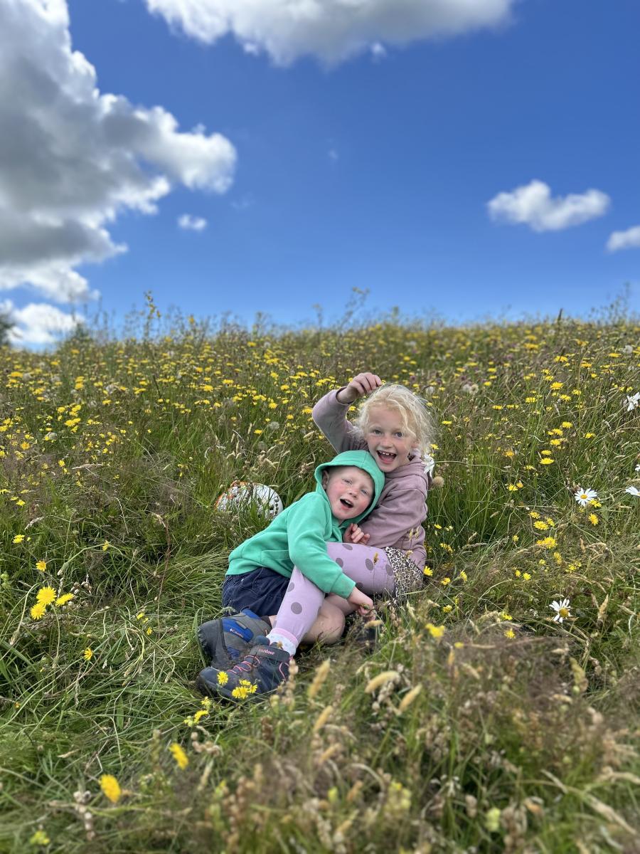 Children in a hay meadow at Meadow Day