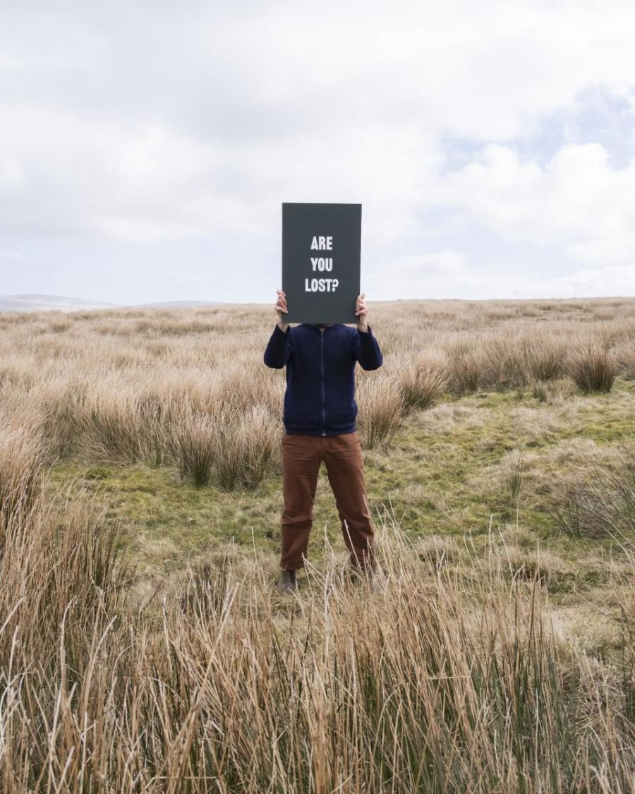 Person holding signage in landscape