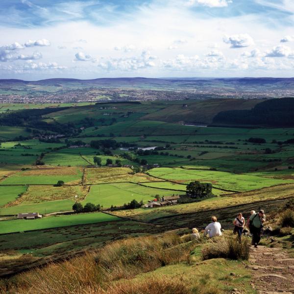 Landscape view from Pendle Hill with walkers climbing the hill