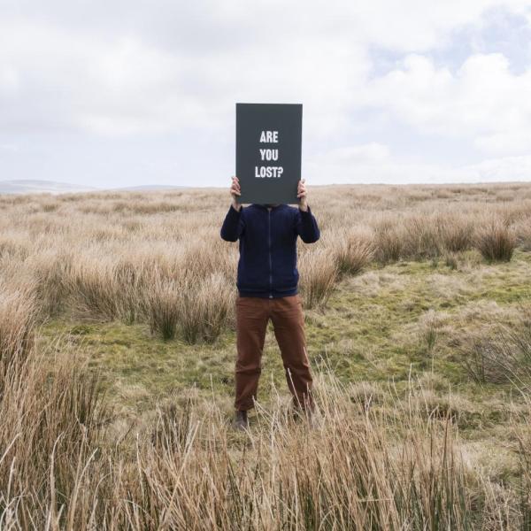 Person holding signage in landscape